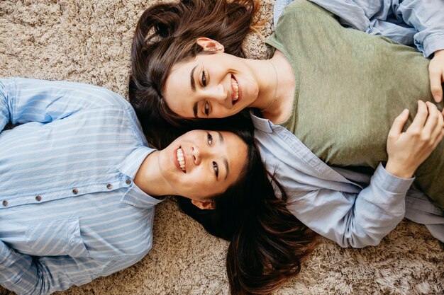 Contenuto che ride i migliori amici che si trovano sul tappeto