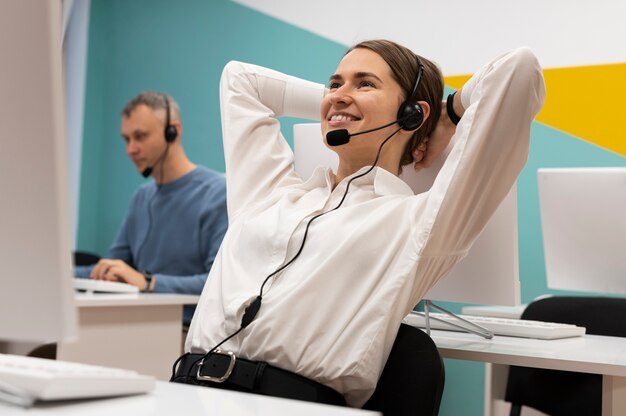 Contenuto donna sorridente che si prende una pausa mentre lavora in un call center