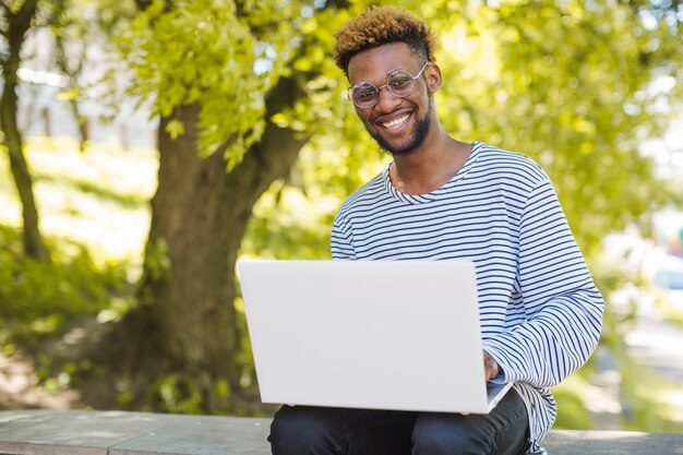 Contenuto nero uomo in posa con il computer portatile