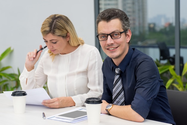 Contenuto uomo d&#39;affari e donna che lavora nel caffè all&#39;aperto.