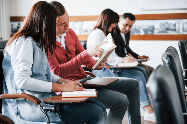 Conversazione attiva. Gruppo di persone alla conferenza di lavoro in aula moderna durante il giorno