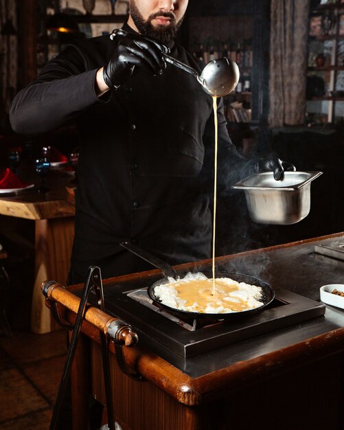 Cook versa le uova riempiendo in padella