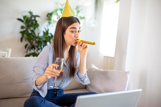 Copia spazio foto di una giovane donna allegra che ha un evento di festa di compleanno con un amico durante una videochiamata Sta facendo un brindisi celebrativo con un bicchiere di vino bianco verso la fotocamera del laptop