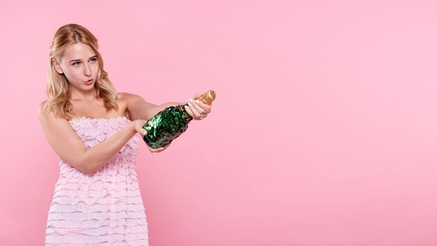Copia-spazio giovane donna schioccando champagne alla festa