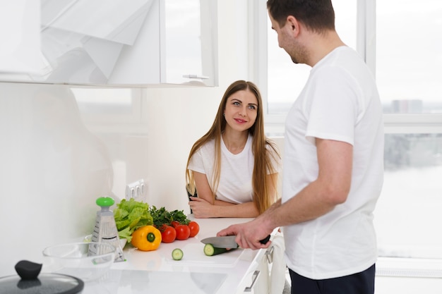 Coppia a casa a preparare insalata