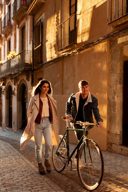 Coppia a tutto campo che cammina con la bicicletta