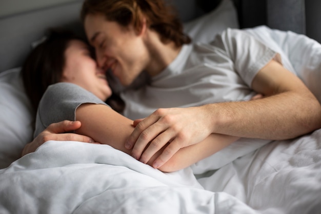 Coppia abbracciando affettuosamente mentre a letto