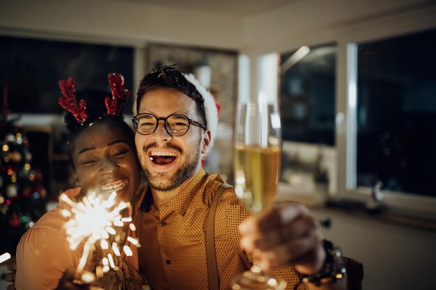 Coppia allegra che festeggia il nuovo anno e si diverte a casa