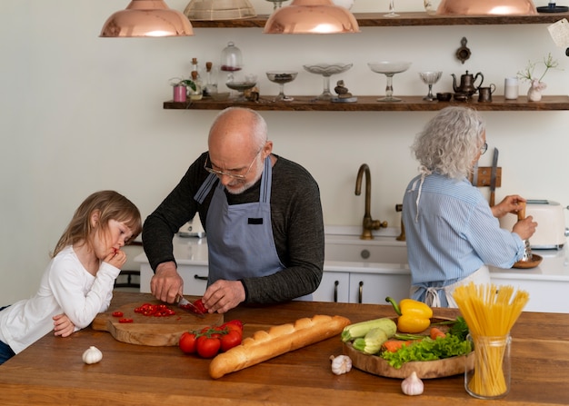 Coppia anziana che cucina insieme in cucina con il nipote
