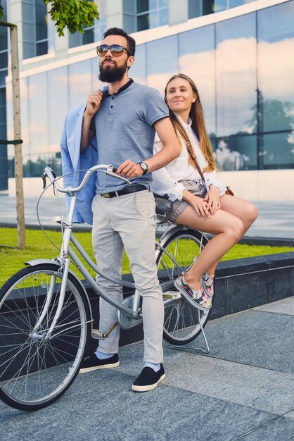 Coppia attraente ad un appuntamento dopo un giro in bicicletta in una città.
