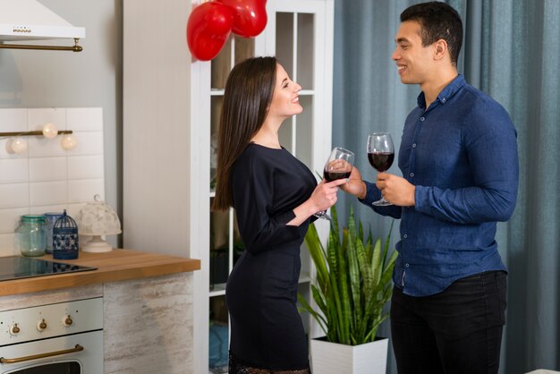 Coppia avere un bicchiere di vino in cucina