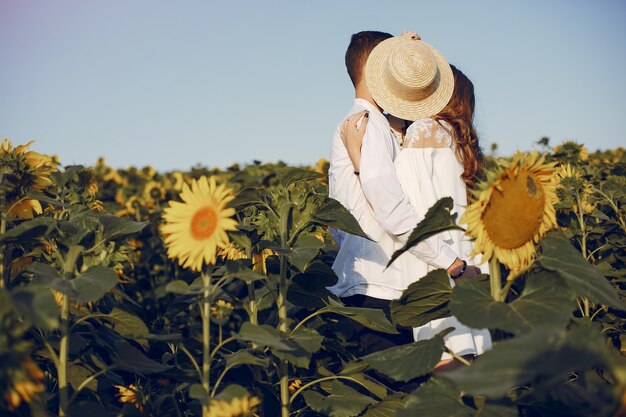 Coppia bella ed elegante in un campo con girasoli