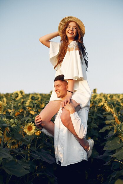 Coppia bella ed elegante in un campo con girasoli