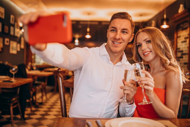 Coppia bere champagne in un ristorante il giorno di San Valentino