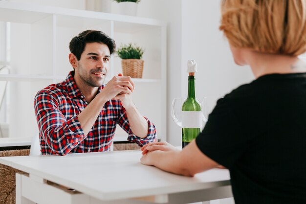 Coppia bere vino e parlando al tavolo