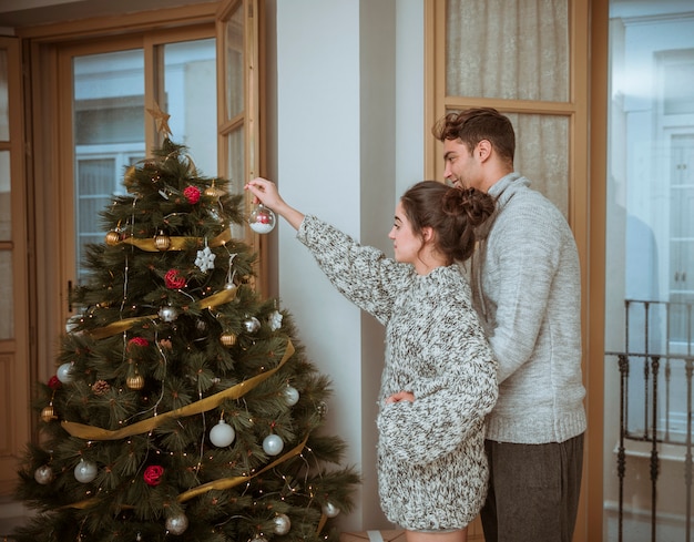 Coppia che decora l&#39;abete per Natale