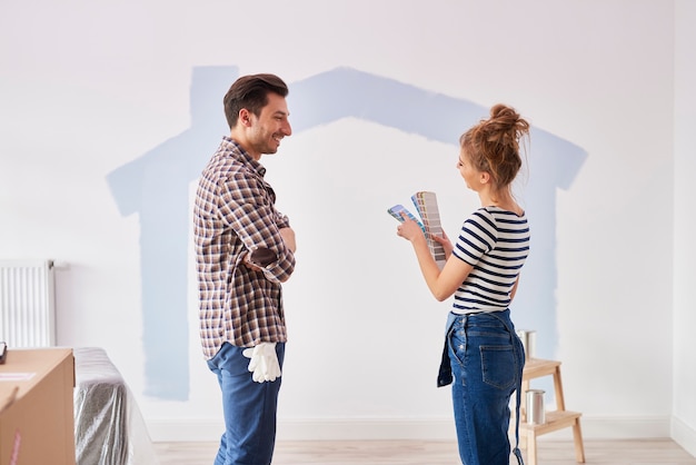 Coppia che dipinge la parete interna del loro nuovo appartamento