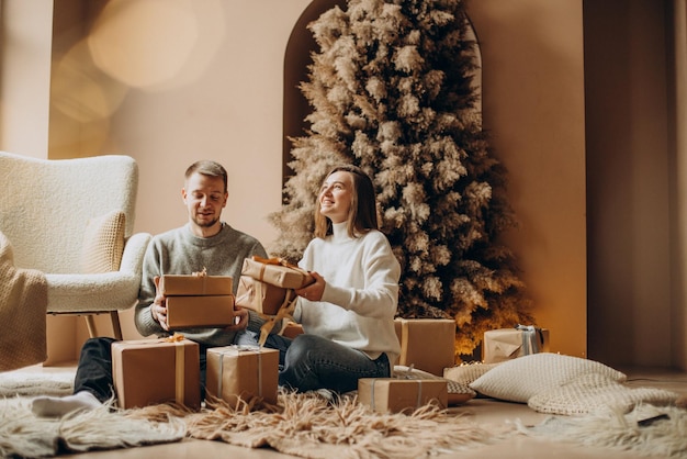 Coppia che festeggia il Natale vicino all'albero di Natale