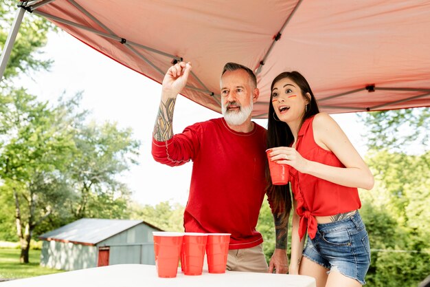 Coppia che gioca a birra pong a una festa sul portellone