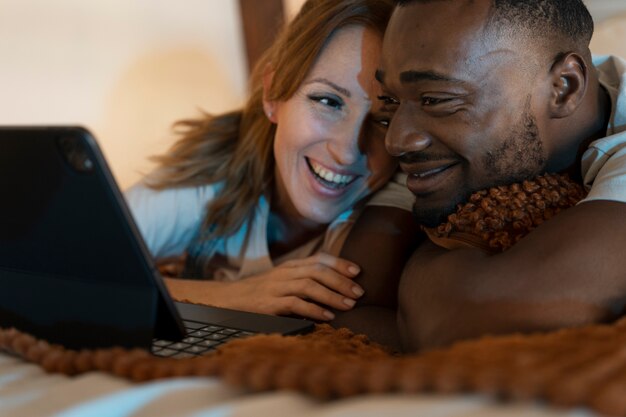 Coppia che guarda il servizio di streaming insieme in camera da letto