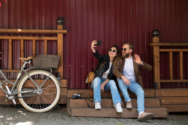 Coppia che indossa giacche di pelle sintetica che si fanno selfie insieme all'aperto