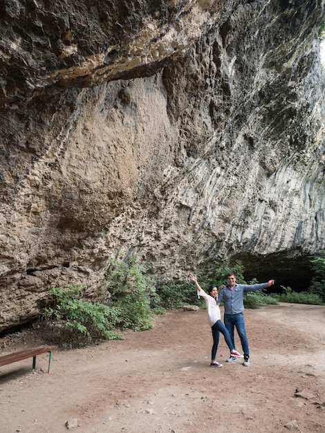 Coppia che si diverte lontano dalla città esplorando una grotta in montagna. Coppia felice in natura.