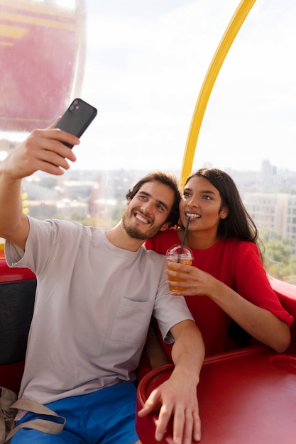 Coppia che si fa selfie mentre si è fuori insieme alla ruota panoramica