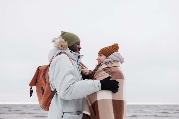 Coppia che si sveglia insieme sulla spiaggia durante un viaggio invernale