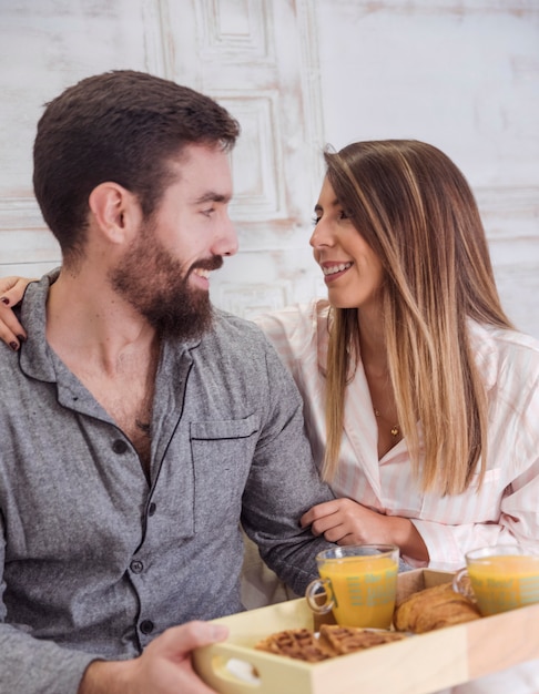 Coppia con colazione sul vassoio in legno