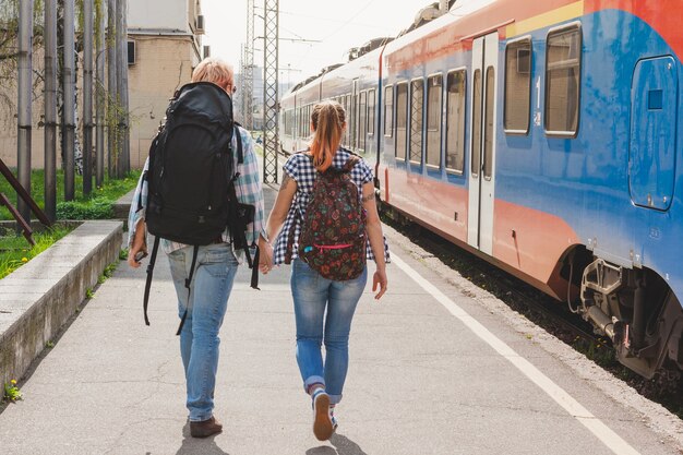 Coppia con lo zaino alla stazione ferroviaria