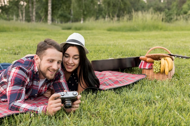 Coppia con una macchina fotografica su una coperta da picnic