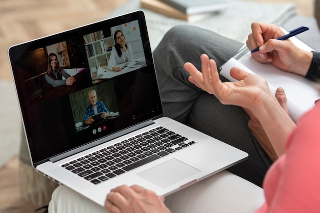 Coppia di anziani a casa sul divano con una videochiamata sul laptop