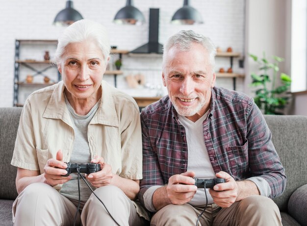 Coppia di anziani che giocano insieme ai videogiochi