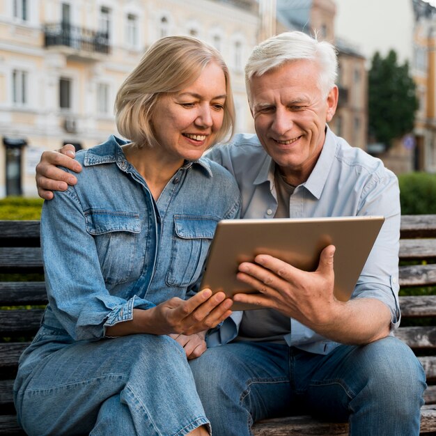 Coppia di anziani di smiley guardando qualcosa sul tablet