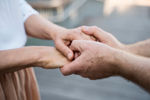 Coppia di anziani mano nella mano insieme all'aperto