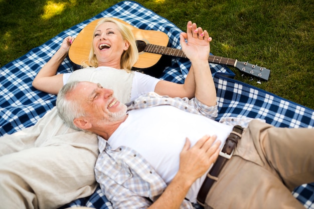 Coppia di anziani ridendo al picnic