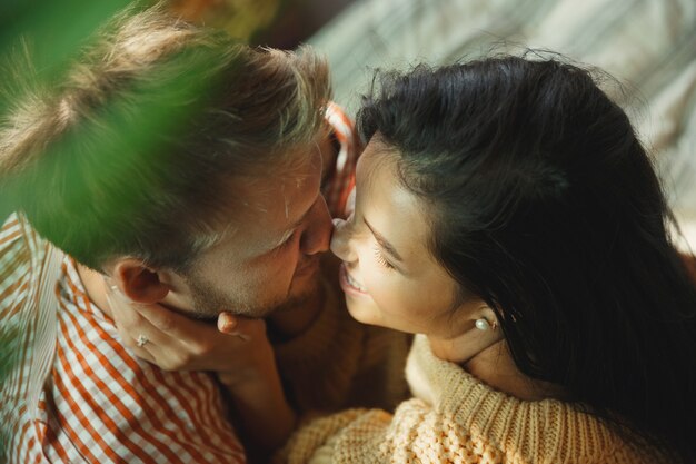 Coppia di innamorati a casa che si rilassano insieme. L'uomo e la donna caucasici che hanno fine settimana, sembrano teneri e felici. Concetto di relazioni, famiglia, comfort autunnale e invernale. Romantico domestico.