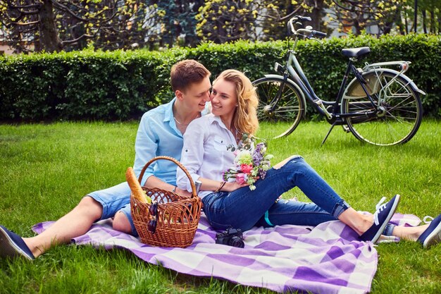 Coppia di innamorati a un picnic dopo un giro in bicicletta in un parco.