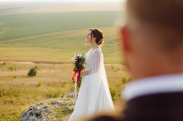 Coppia di innamorati matrimonio sposini fuori al tramonto in una bella giornata estiva