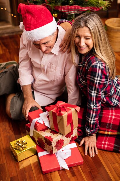 Coppia di mezza età con i regali a Natale