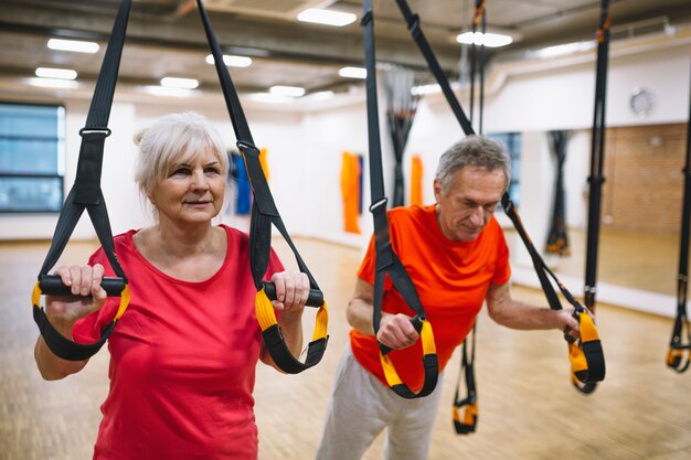 Coppia di pensionati allenandovi in ​​palestra