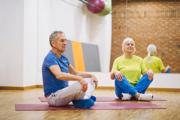 Coppia di pensionati facendo yoga