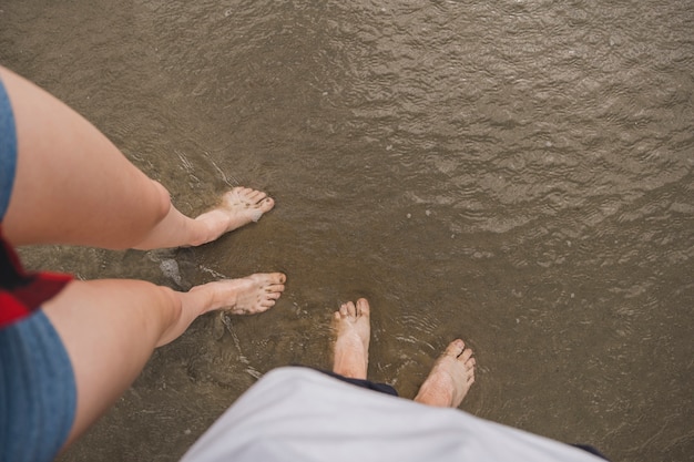 Coppia di piedi nudi sull'acqua sulla spiaggia