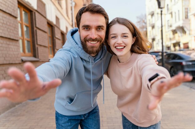 Coppia di smiley prendendo un selfie e fingendo di raggiungere