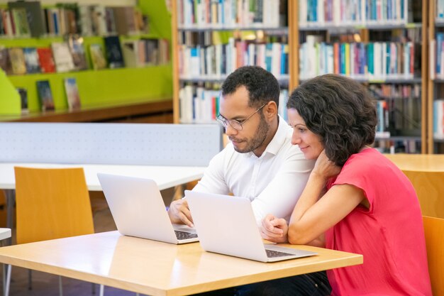 Coppia di studenti adulti che fanno e discutono di ricerca accademica