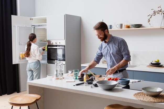 Coppia di tiro medio che cucina in cucina