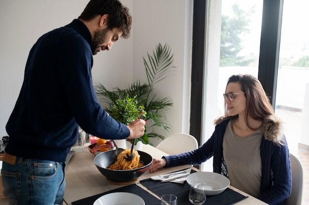 Coppia di tiro medio con cibo a casa