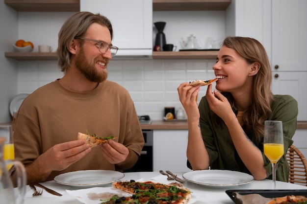 Coppia di tiro medio con pizza deliziosa