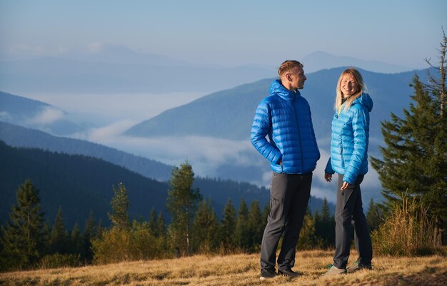 Coppia di viaggiatori innamorati che camminano in montagna