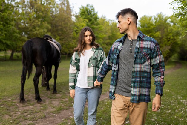 Coppia e cavallo all'aperto tiro medio